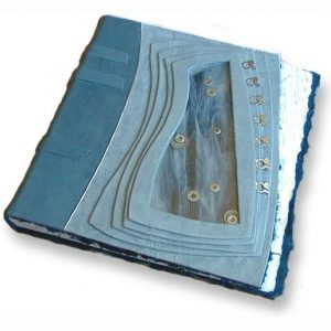 light blue suede handbound baby book with silver washers moving between panes of glass, kinetic photo album