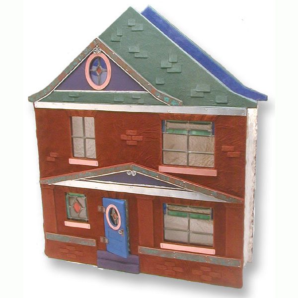 house shaped leather scrapbook with leaded glass windows, hinged blue door, purple dormer, green roof, and brown leather bricks