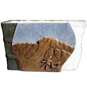handvcarved mountain landscape embossed under brown lather on book cover with suede blue sky and chinese character for Harmony