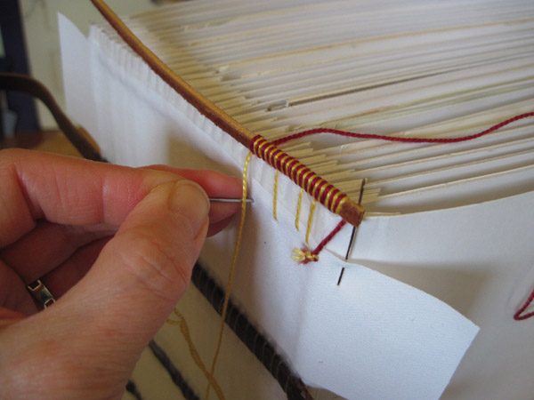 Sewing handstiched headbands on a photo album
