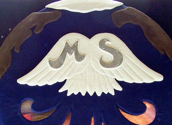 White leather embossed wings on globe