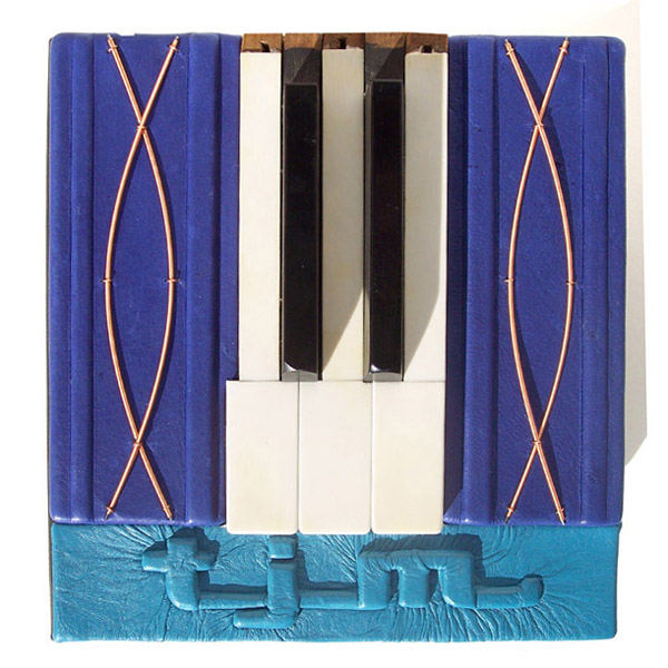 top cover of pianist custom leather box with piano keys, piano wire, and embossed initials TJM
