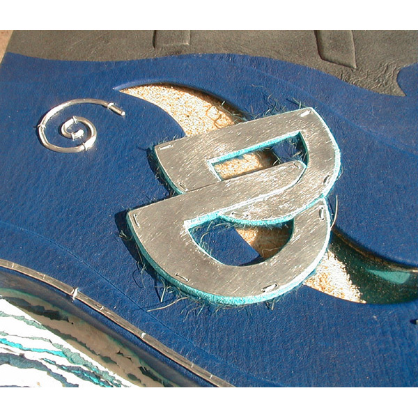 sand window with D D initials on blue leather book cover, glass window