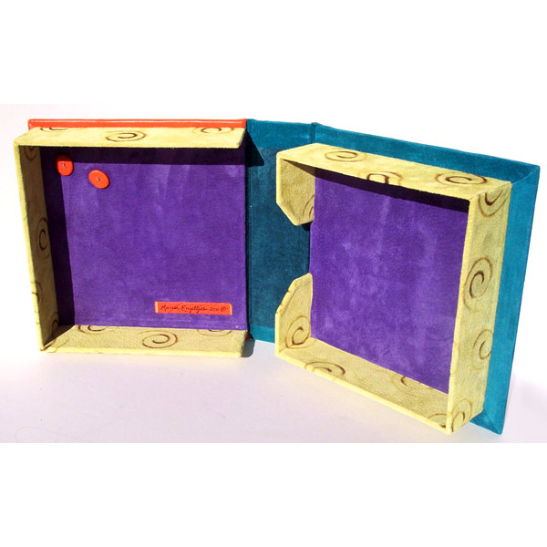 clamshell leather box interior with purple base, limes green spiral branded walls, and orange leather dots inside