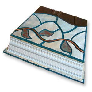 askew shaped handbound book with silver mosaic panels around a copper vine