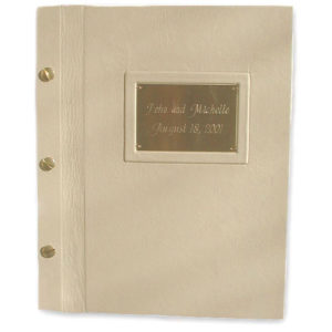framed etched metal name plate on beige leather book cover bound with brass screwposts as wedding album