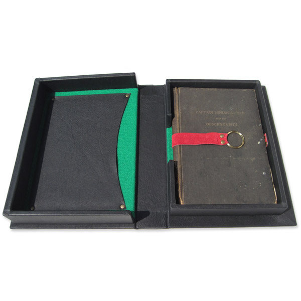 leather clamshell box holding antique book with red pull strap