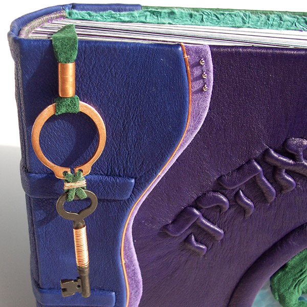 Skeleton Key leather pagemarker on blue and purple leatherbound book with Hebrew embossed lettering