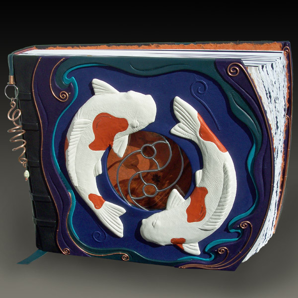 Circling Koi fish sculptures around leaded glass yin yang window on leather scrapbook
