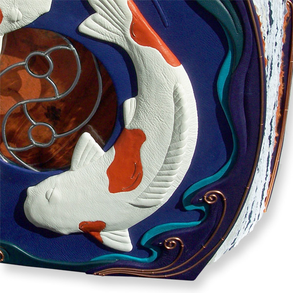 carved and leather wrapped koi fish circling around yin yang glass window