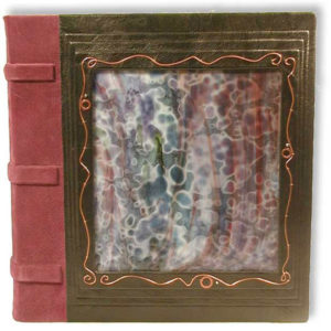 Leather wedding album with mottled stained glass window, copper wire filigree, and black and burgundy leathers.