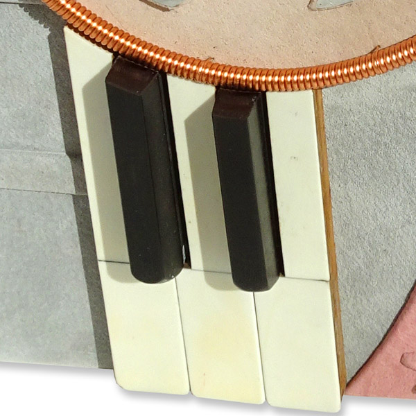 antique ebony and ivory piano keys on leather photo album cover with copper piano wire