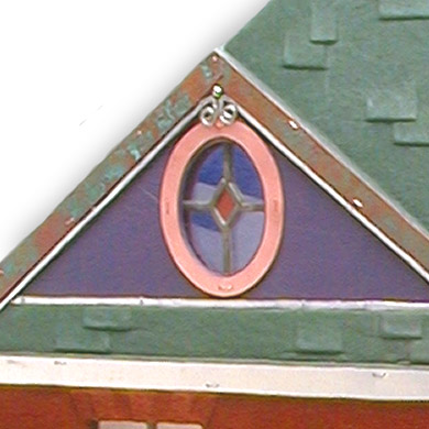 leather house shaped book detail of dormer with purple leather, green shingles and oval leaded glass window with copper frame