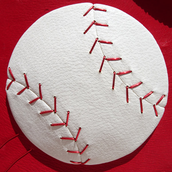 White Leather Baseball Sculpture with Red Wire Stitches on Book Cover